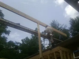 Carpenter setting a ridge beam over a new addition frame — Ice Dam Removal by Roofing Brothers in Zuni