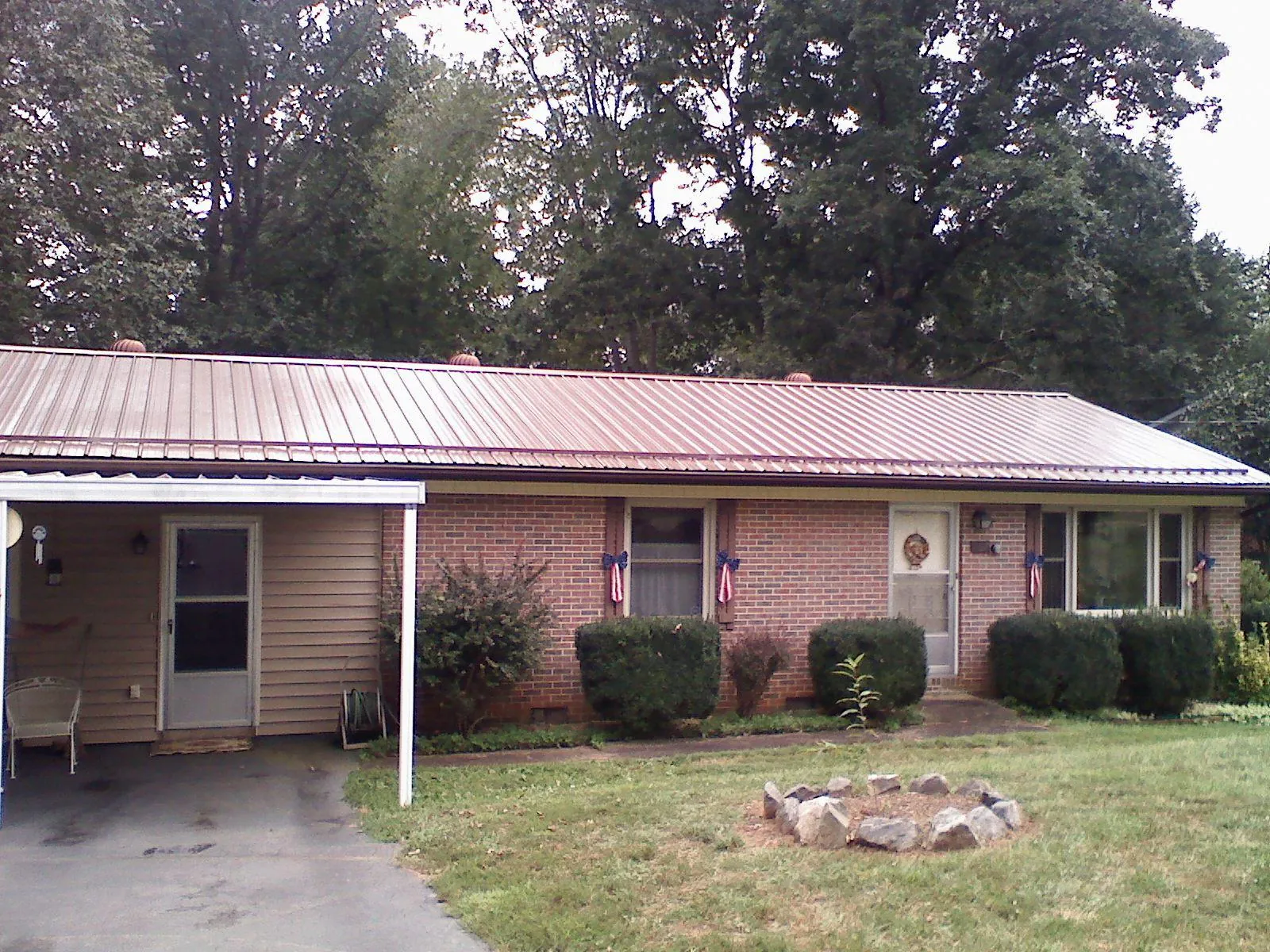 Bronze metal roof and carport on a brick ranch home — Roof Repair work by our crew in Zuni