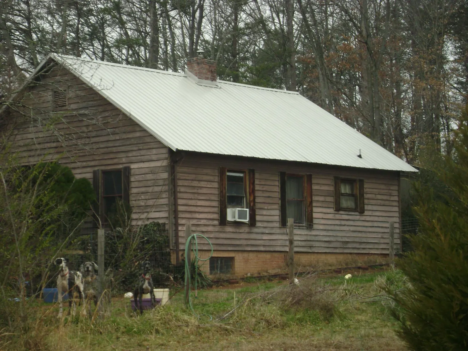 White metal roof on an old wood sided farmhouse, from a Metal Roof Installation job in Zuni
